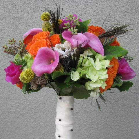 Peacock feathers are tucked low into the bouquet to add the perfect amount 